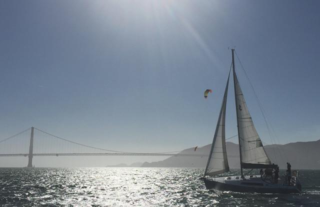 Sailing across San Francisco Bay with the Golden Gate Bridge in the background, student practice skills learned in Basic Keelboat (ASA 101) and Basic Coastal Cruising (ASA 103) 5-day Combination Course at Modern Sailing School and Club